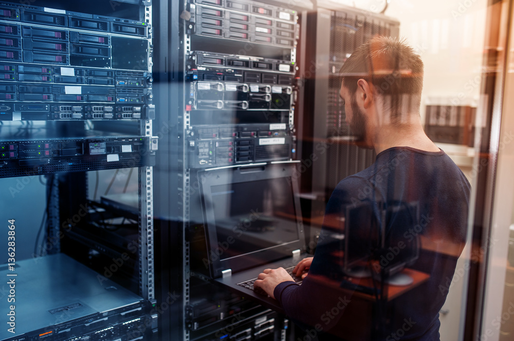 Infrastructure engineer working at a server rack in a data centre